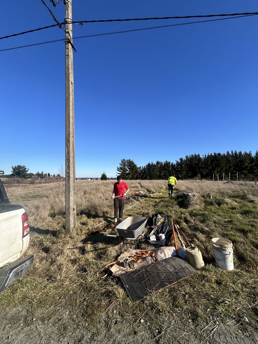 Evaluación en terreno junto al poste existente, revisando el punto de conexión y las condiciones de la parcela