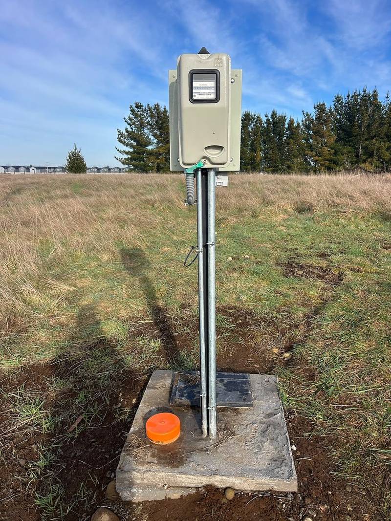 Empalme eléctrico de parcela con medidor instalado junto al poste, trabajo terminado