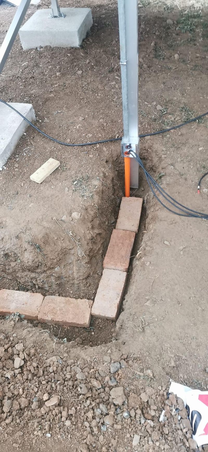 Canalización subterránea emergiendo junto a la estructura del sistema fotovoltaico para el ingreso de conductores a los equipos